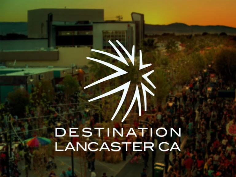 Lancaster, California cityscape at sunset with logo overlay.