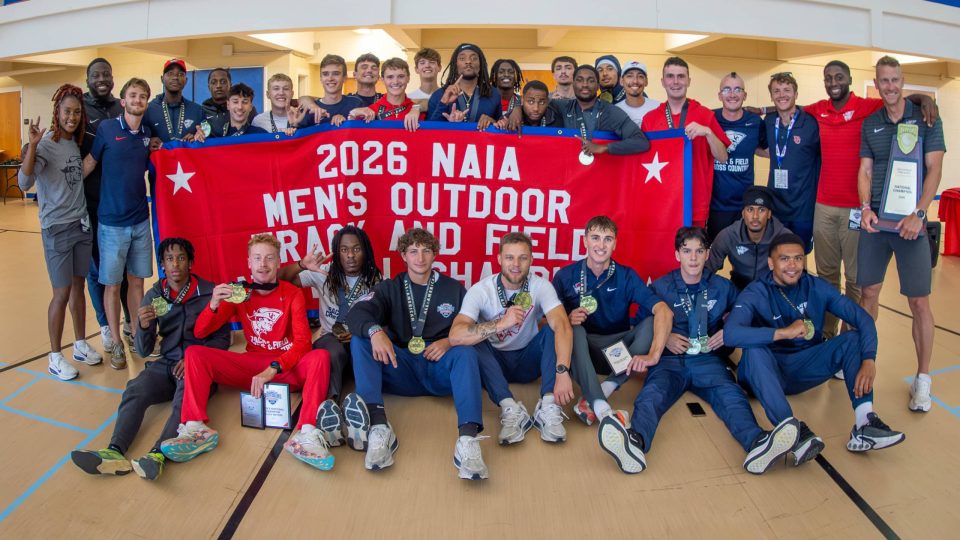 2026 NAIA Men's Outdoor Track and Field team group photo indoors.