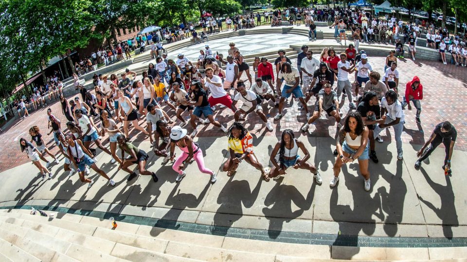 Jumping crowd of people in a public park during daytime.